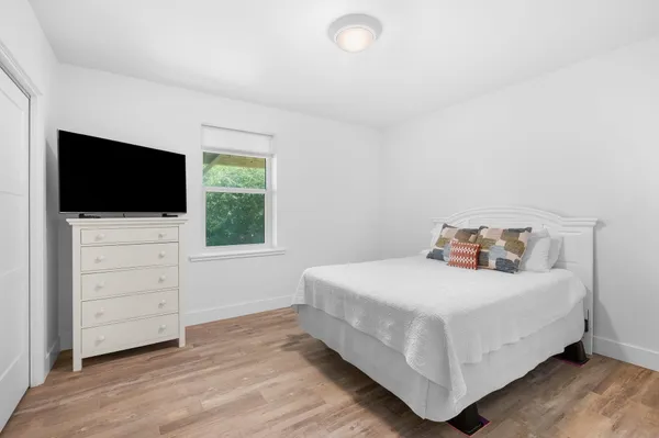 a bedroom with a bed and a flat screen tv