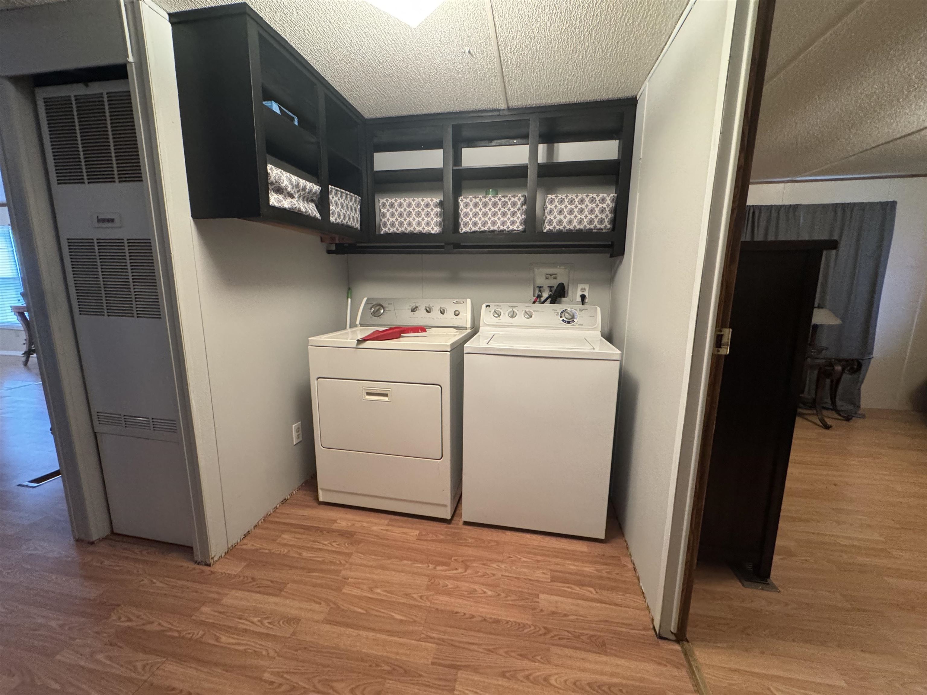 2511 Watkins Road Michie, TN 38357 - Photo 19 of 40 Laundry area with wood-finish flooring, overhead shelving, and a built-in furnace unit