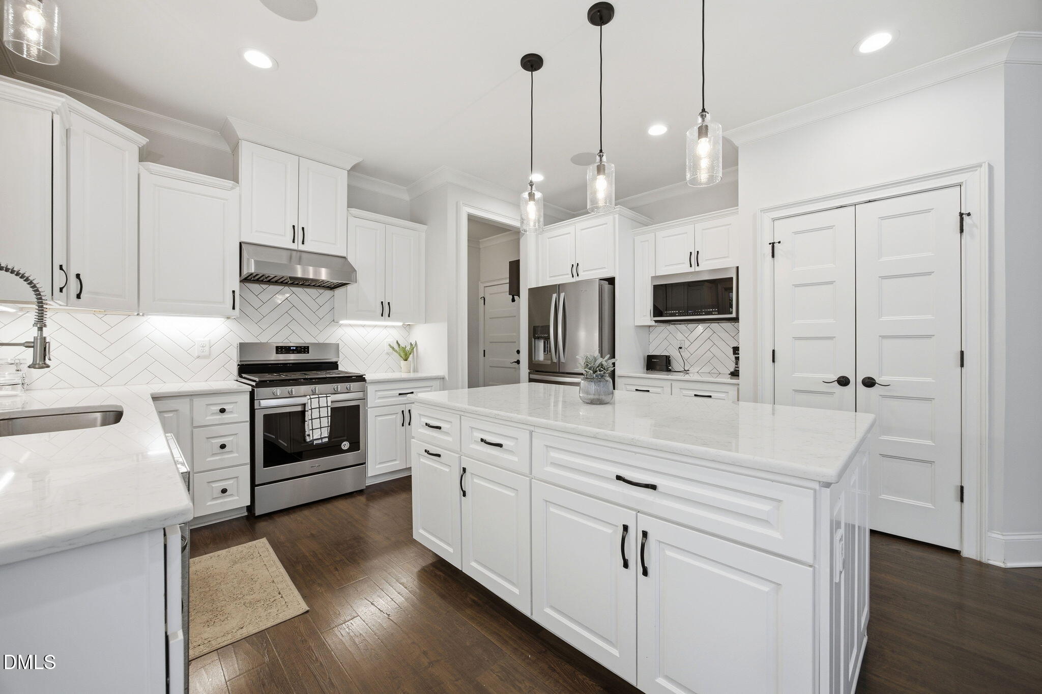 211 Long Street Fuquay-Varina, NC 27526 - Photo 11 of 38 a large kitchen with white cabinets and stainless steel appliances