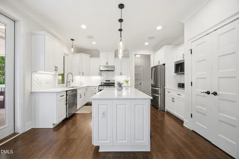 a kitchen with white cabinets and stainless steel appliances
