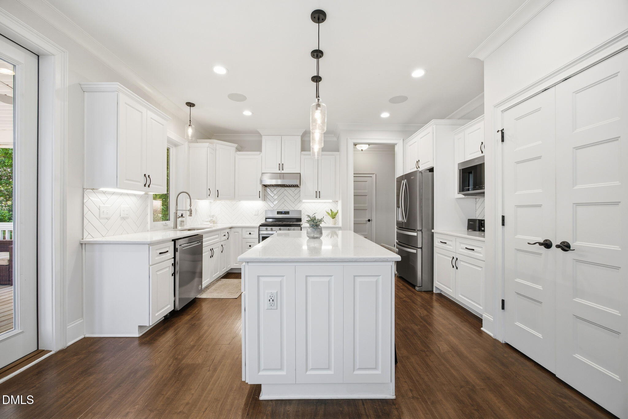 211 Long Street Fuquay-Varina, NC 27526 - Photo 12 of 38 a kitchen with white cabinets and stainless steel appliances