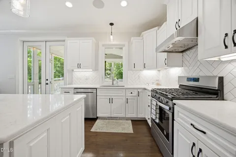 a kitchen with granite countertop a sink stove and cabinets