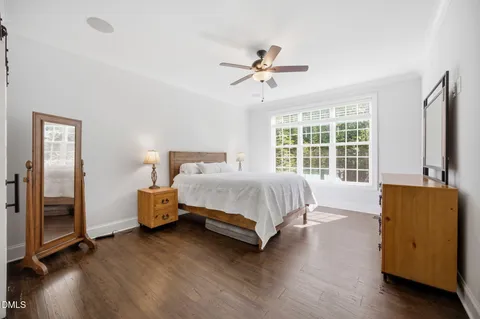 a bed sitting in a spacious bedroom next to a window