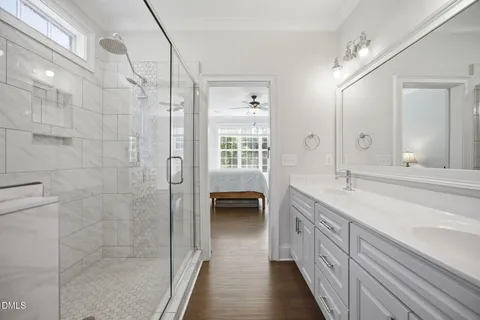 a bathroom with a double vanity sink a toilet and a shower