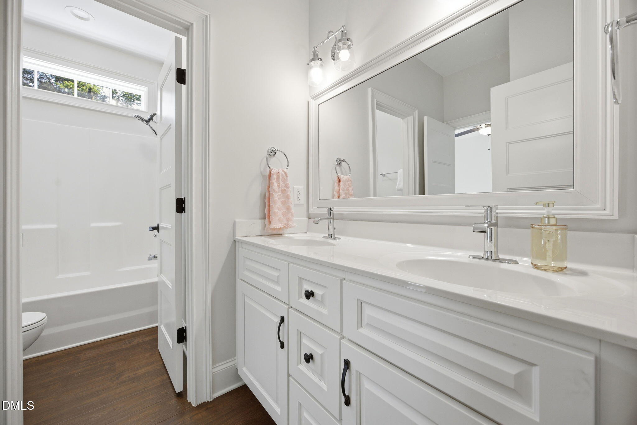 211 Long Street Fuquay-Varina, NC 27526 - Photo 22 of 38 a bathroom with a double vanity sink a mirror and a bathtub