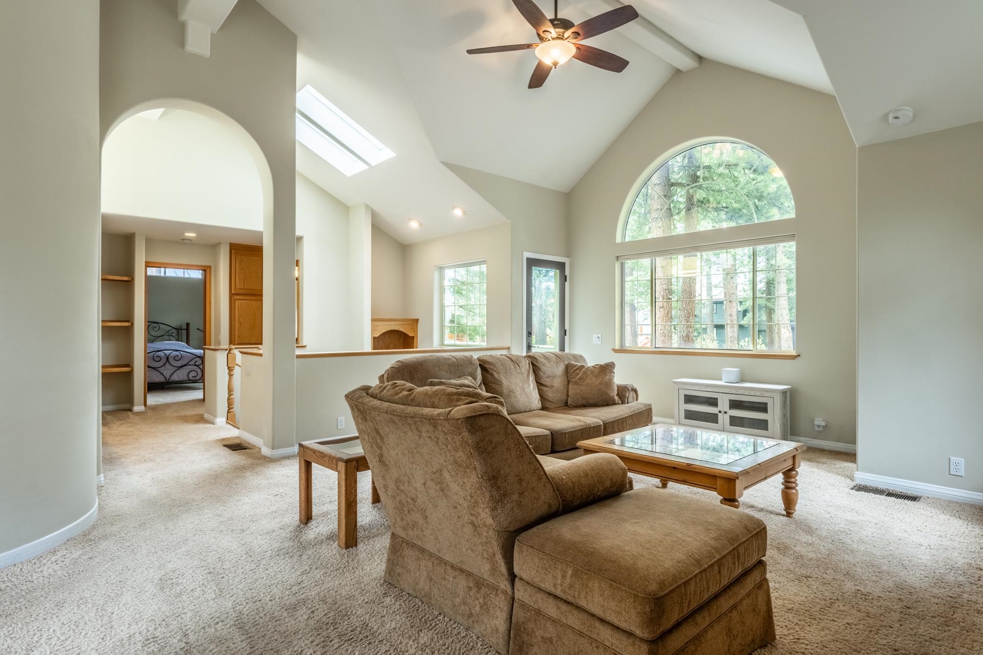 272 Ridge Way Mammoth Lakes, CA 93546 - Photo 13 of 55 Vaulted ceiling living room featuring a large arched window with natural light, a ceiling fan, and carpeted flooring