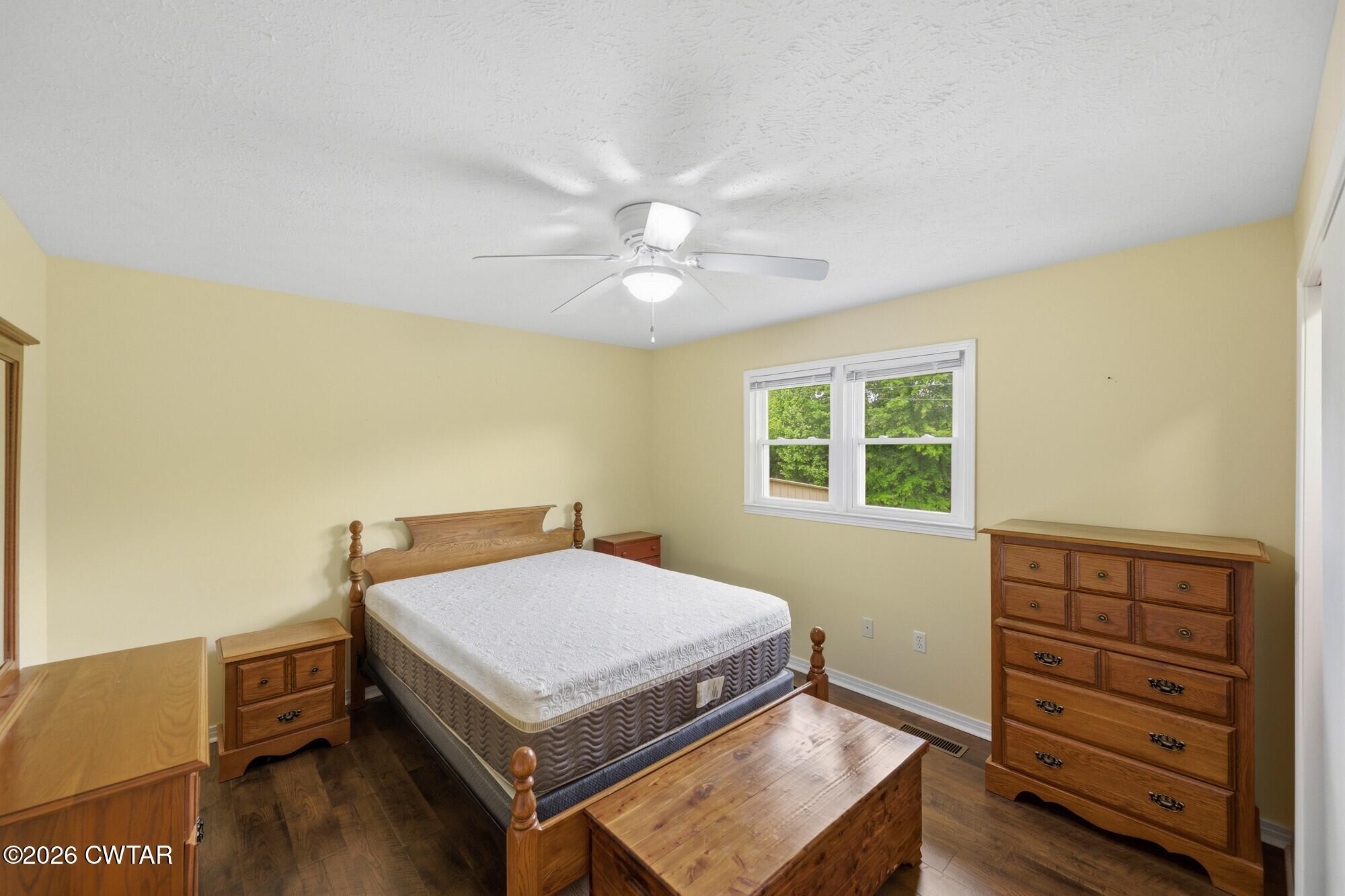 944 Brooksie Thompson Road Decaturville, TN 38329 - Photo 24 of 47 a bedroom with a bed and wooden floor