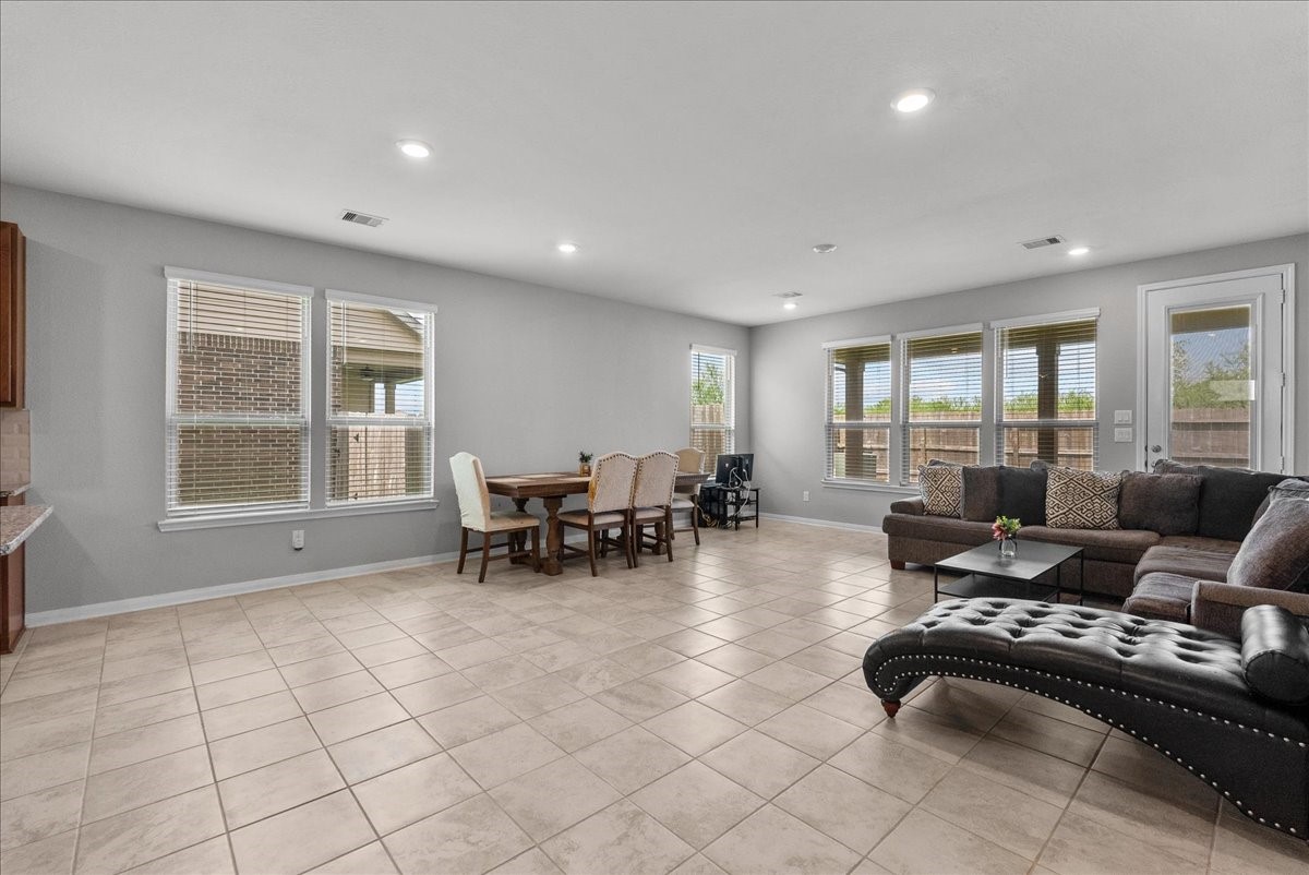 2320 Rosemary Street Rosenberg, TX 77469 - Photo 17 of 40 A spacious, open-concept living area with large windows, tile flooring, and neutral walls.