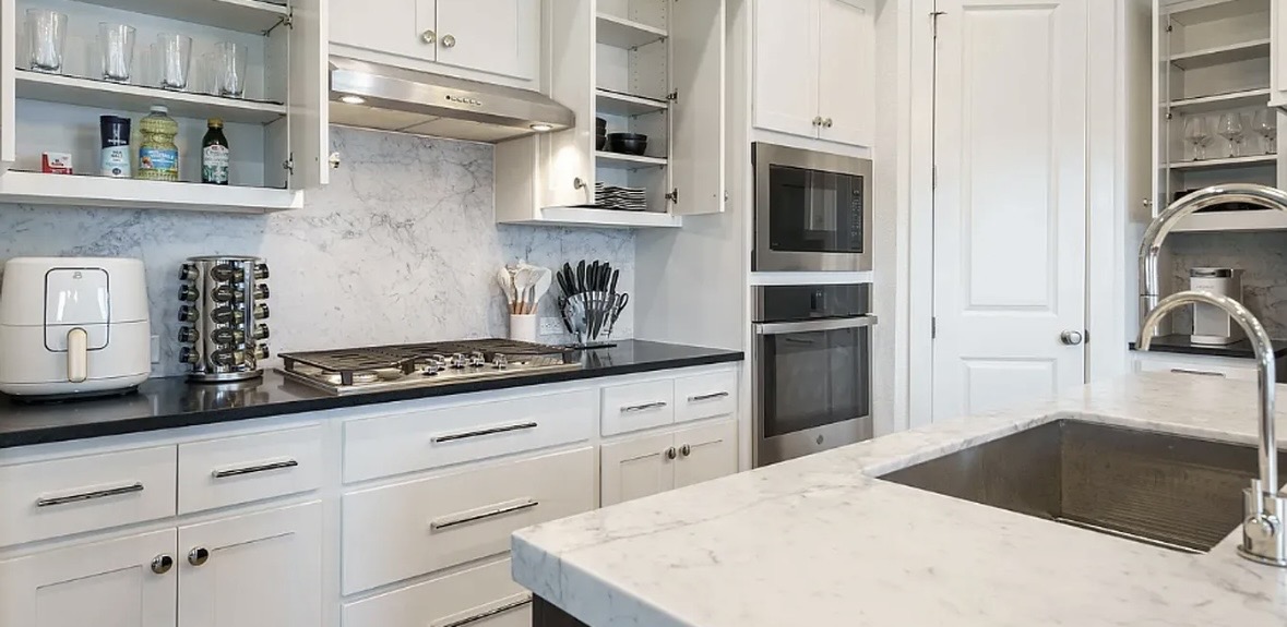 109 Arrowhead Mound Road Georgetown, TX 78628 - Photo 24 of 27 White cabinetry, quartz countertops, and stainless steel appliances outfit this well-appointed kitchen.