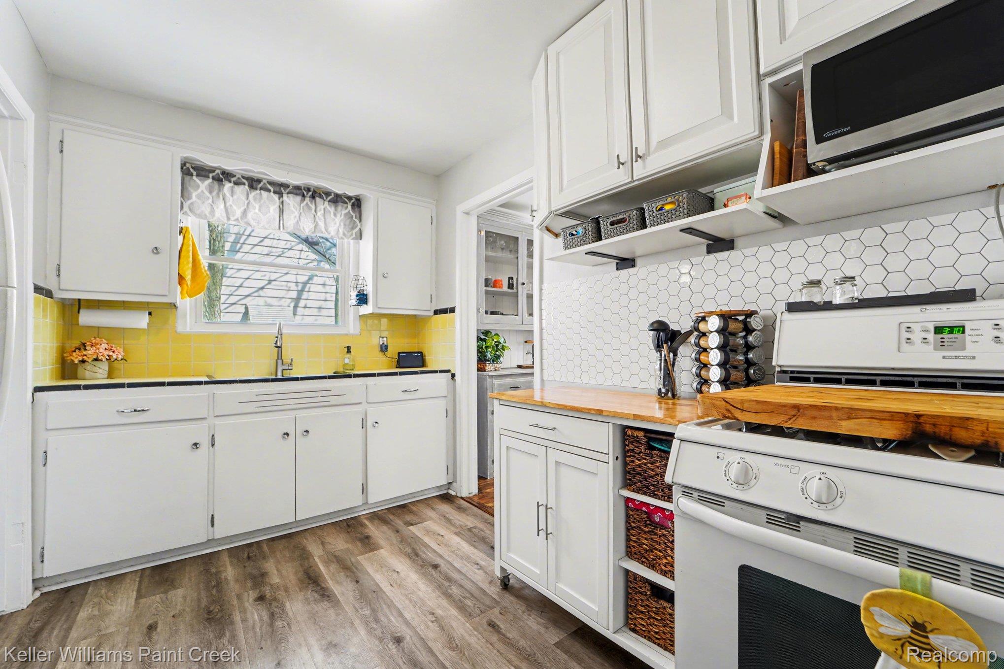 1404 West Eleven Mile Road Berkley, MI 48072 - Photo 5 of 20 The kitchen is darling with a mix of retro finishes and practical updates, offering ample cabinetry, updated flooring, appliances, and a layout that’s easy to work within.
