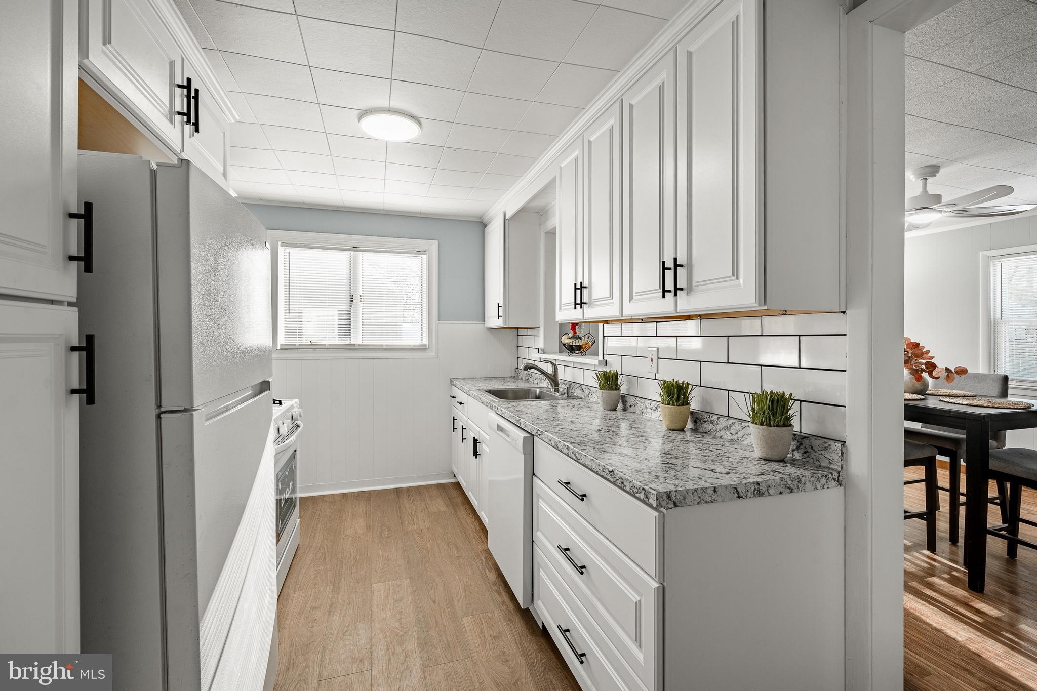 8 Garrett Road Wilmington, DE 19809 - Photo 7 of 37 a kitchen with granite countertop a sink stove and cabinets