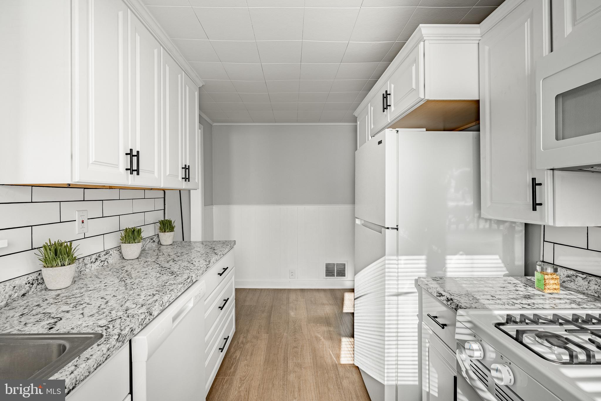 8 Garrett Road Wilmington, DE 19809 - Photo 10 of 37 a kitchen with granite countertop a sink stove and cabinets