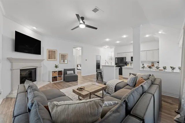 a living room with furniture a fireplace and flat screen tv