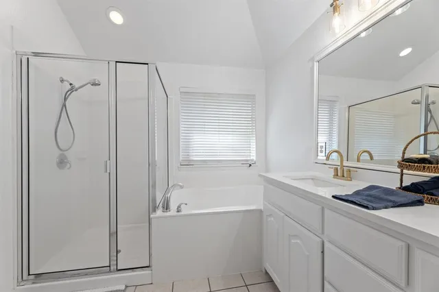 a bathroom with a granite countertop sink a mirror and a bathtub
