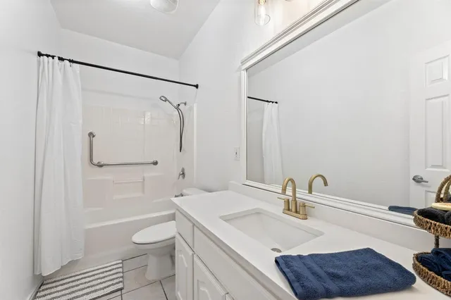 a bathroom with a granite countertop sink a toilet and shower