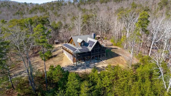 a kitchen with stainless steel appliances granite countertop a refrigerator a sink a stove top oven and a dining table with wooden floor