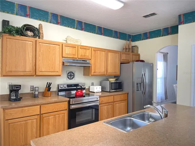 a kitchen with stainless steel appliances granite countertop a refrigerator sink and microwave