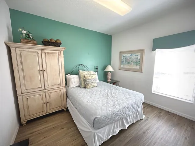 a bedroom with a bed a flat screen tv and a bookshelf