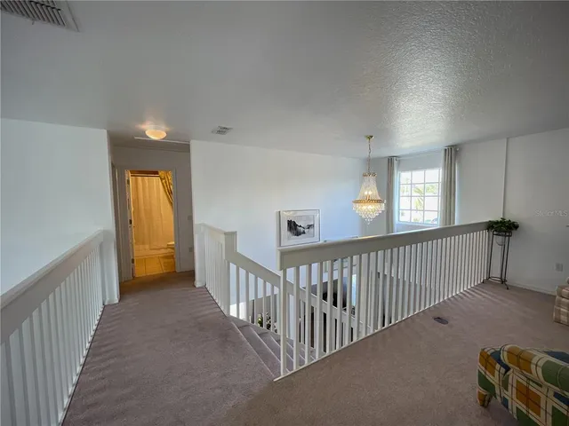 a bedroom with a bed a chandelier and a dresser