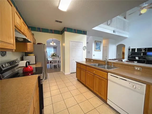 a kitchen with stainless steel appliances granite countertop a sink a refrigerator and a stove