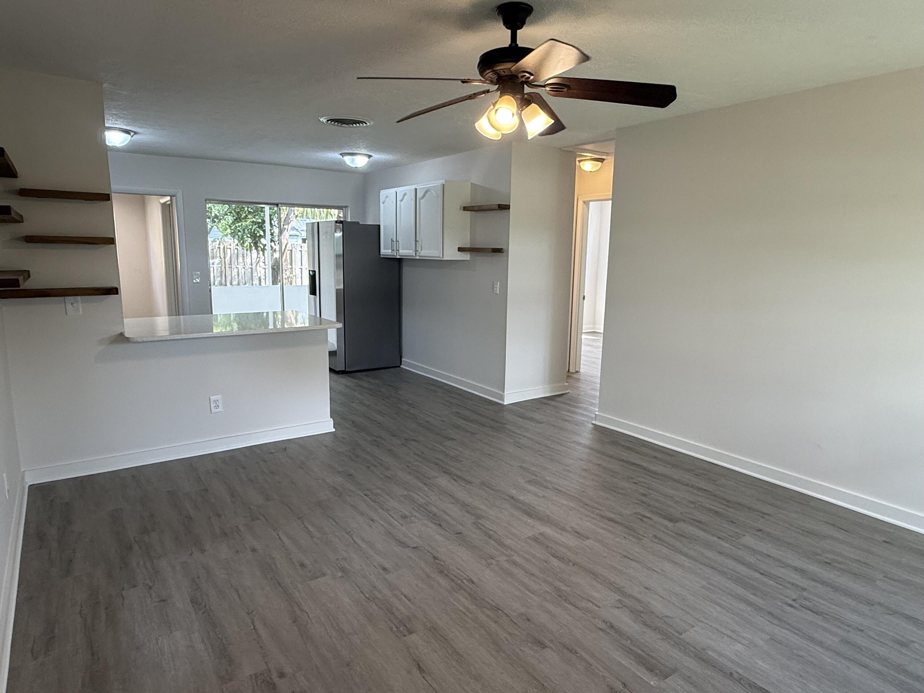 2369 Northeast Rustic Way Jensen Beach, FL 34957 - Photo 3 of 11 a view of an empty room with window and wooden floor