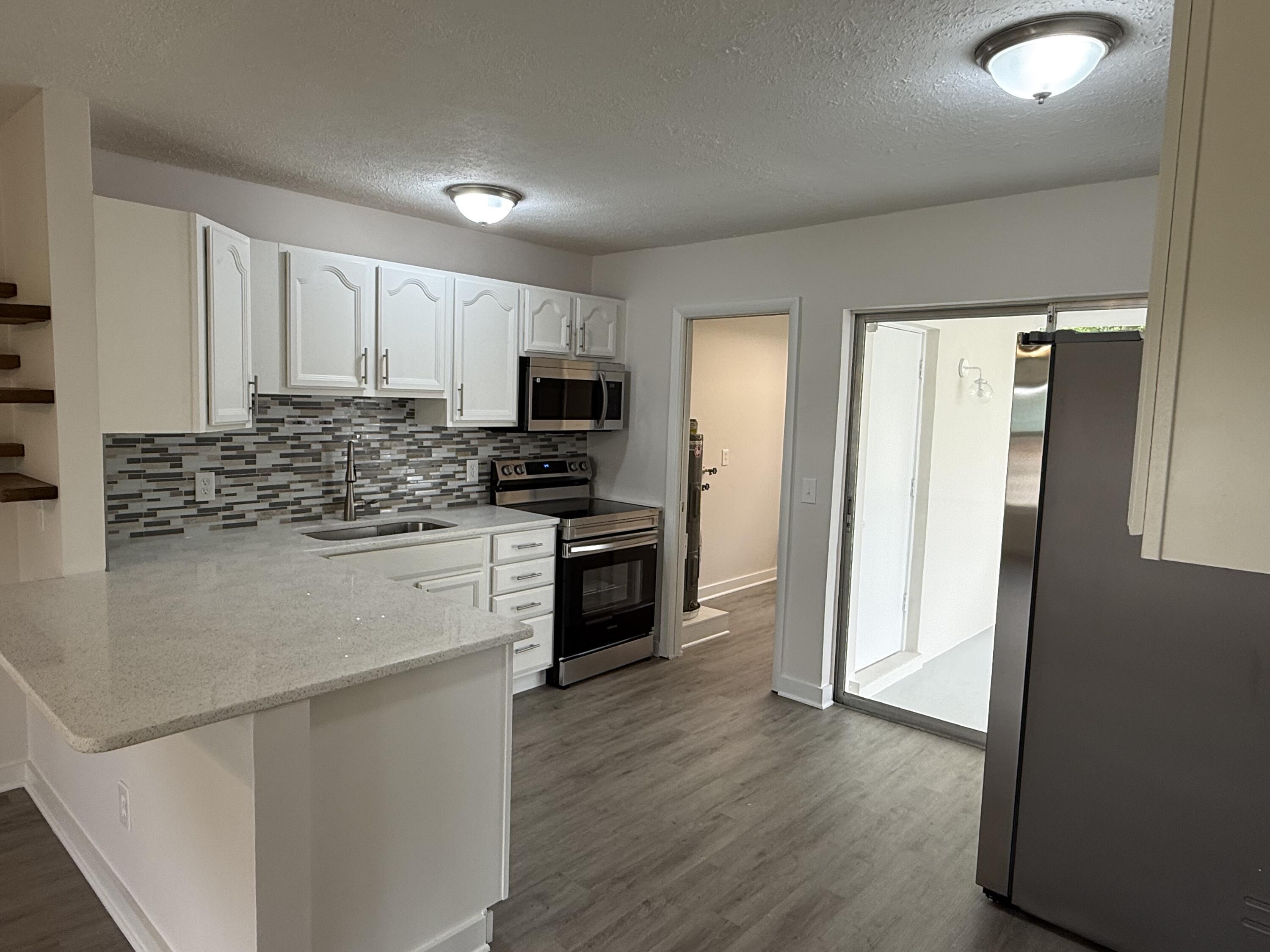 2369 Northeast Rustic Way Jensen Beach, FL 34957 - Photo 4 of 11 a kitchen with appliances a sink and a microwave