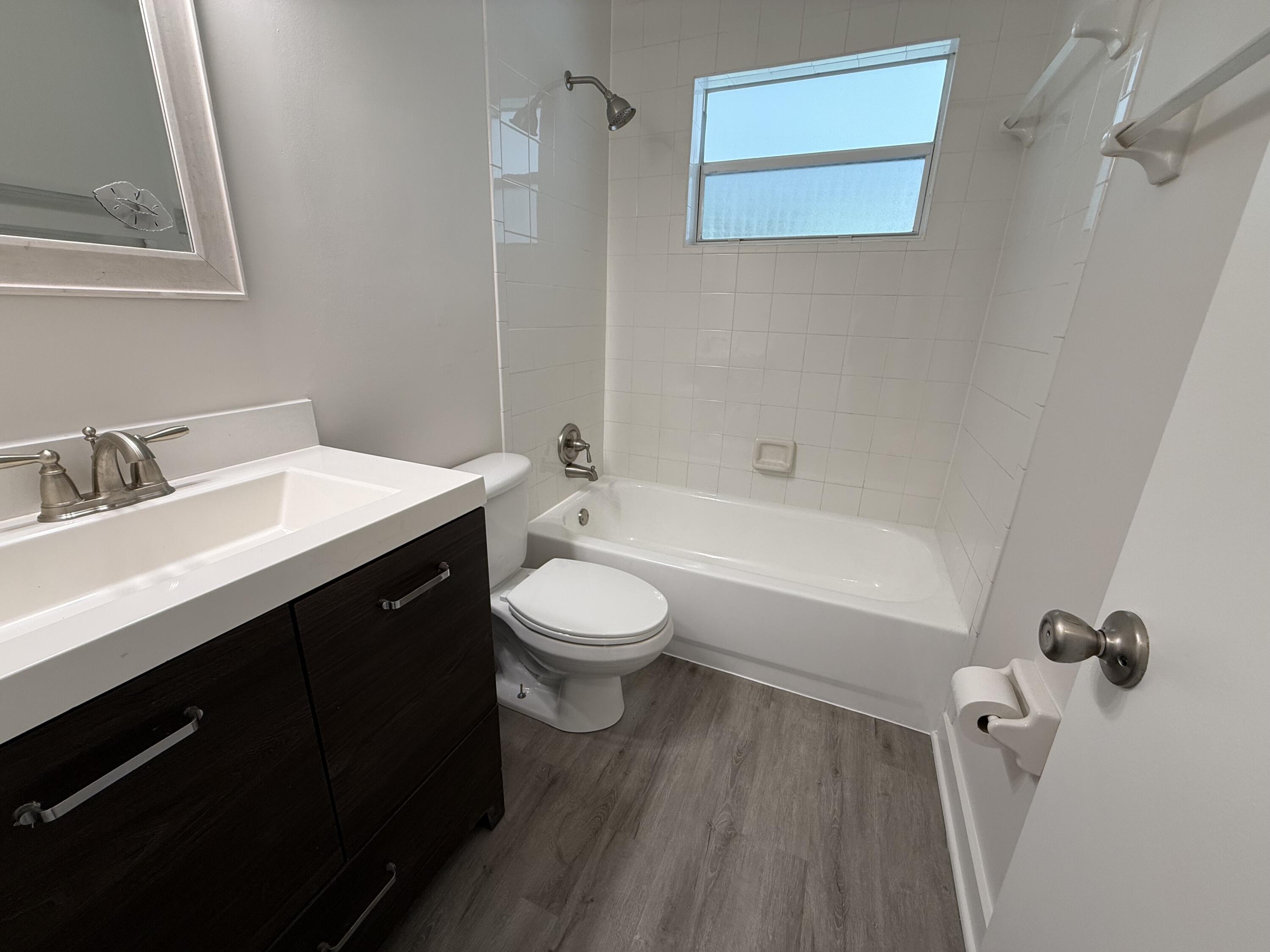 2369 Northeast Rustic Way Jensen Beach, FL 34957 - Photo 7 of 11 a bathroom with a sink a toilet and shower