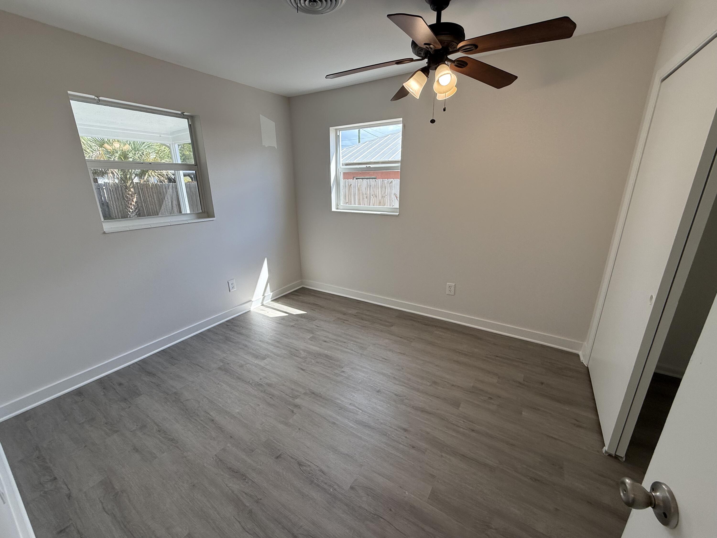 2369 Northeast Rustic Way Jensen Beach, FL 34957 - Photo 8 of 11 wooden floor in an empty room with a window