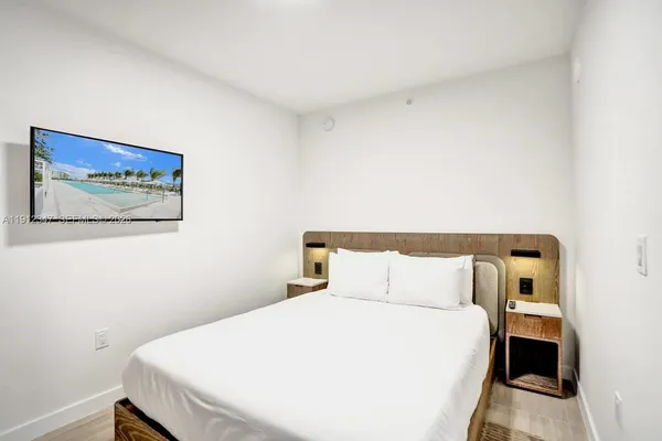 a bedroom with a bed and a wall painting