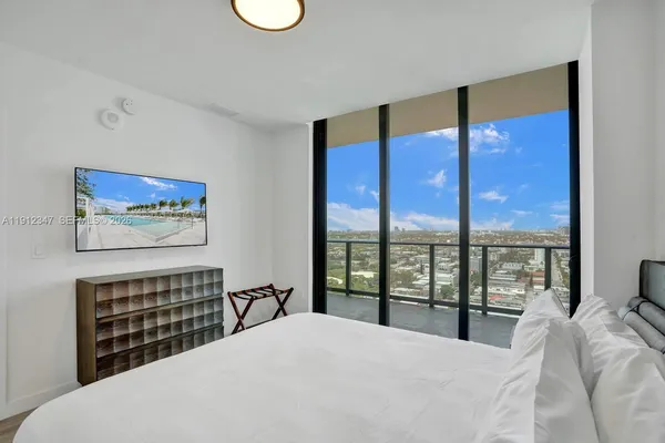 a bedroom with a large bed and a large window