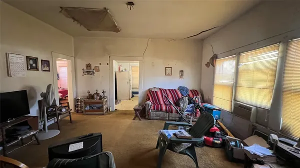 a living room with furniture a flat screen tv and a window