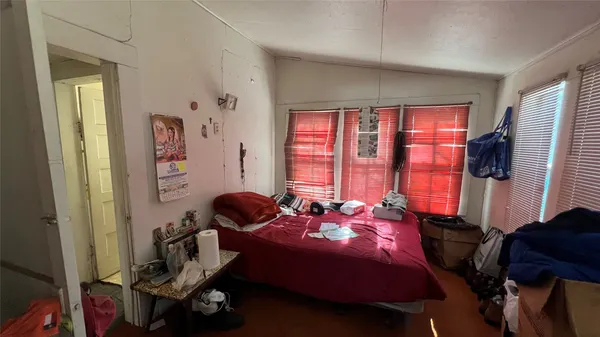 a bedroom with a bed and large windows