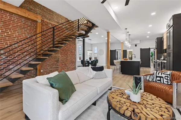 a living room with furniture kitchen view and a chandelier