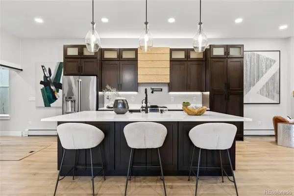 a kitchen with stainless steel appliances kitchen island granite countertop a sink and chairs