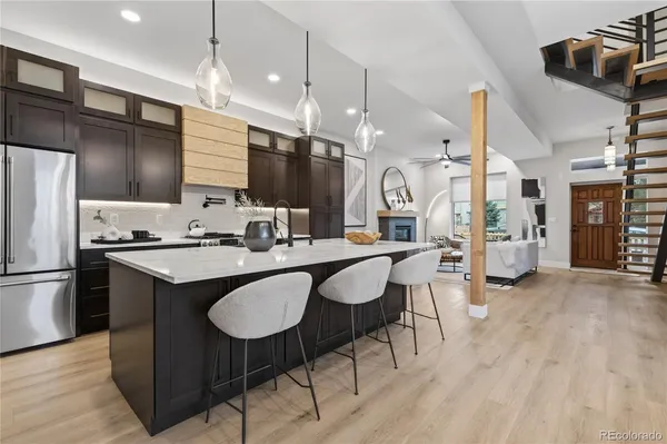 a kitchen with stainless steel appliances granite countertop a sink a stove and a refrigerator