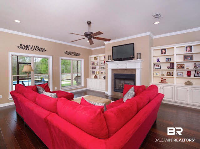 7814 Balin Drive Daphne, AL 36527 - Photo 5 of 26 Spacious Great Room with beautiful floors, a fireplace, built in shelving and a great view of the beautiful pool area connect with the kitchen for an awesome entertaining space!