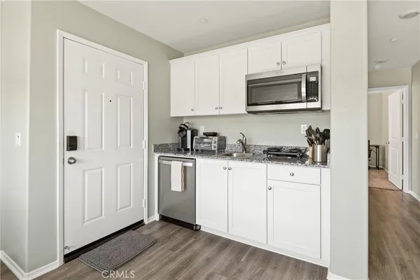 a kitchen with white cabinets and stainless steel appliances