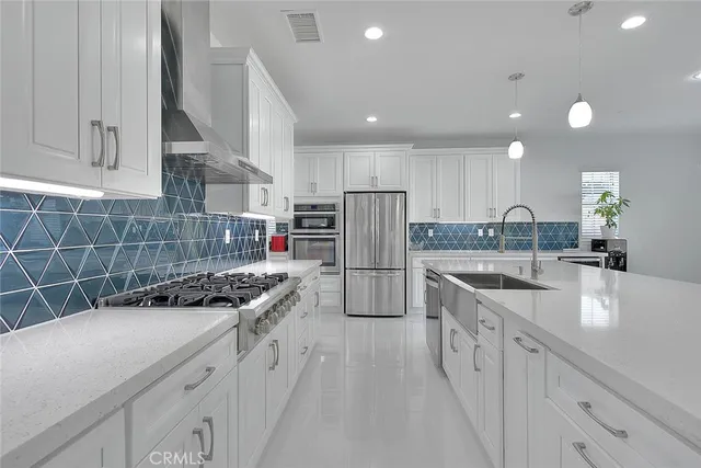 a kitchen with stainless steel appliances a sink stove and cabinets