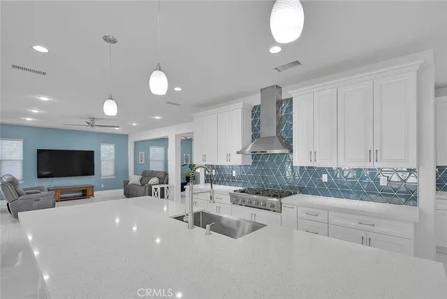 a kitchen with stainless steel appliances a sink a stove a microwave a sink and cabinets