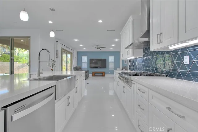 a large kitchen with stainless steel appliances lots of counter space and a sink
