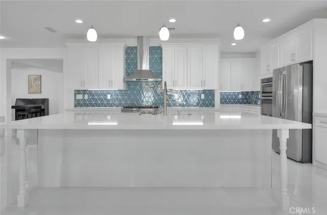a view of a kitchen with kitchen island a sink stainless steel appliances and cabinets