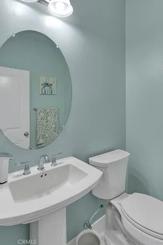 a bathroom with a sink mirror and toilet