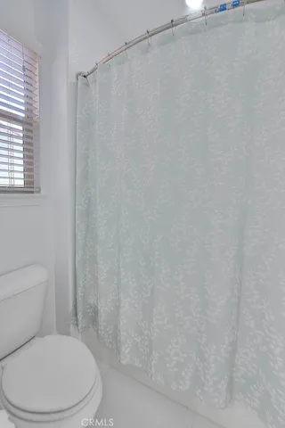 a white toilet sitting next to a shower curtain