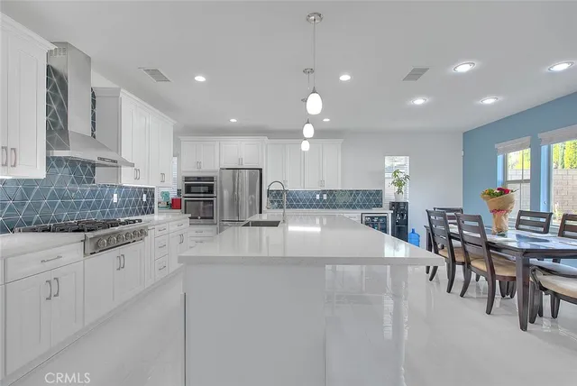 a large kitchen with stainless steel appliances lots of counter space and windows