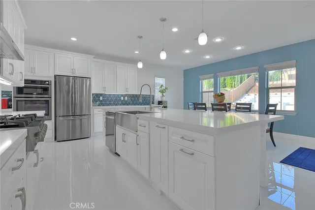 a kitchen with stainless steel appliances a refrigerator sink and stove