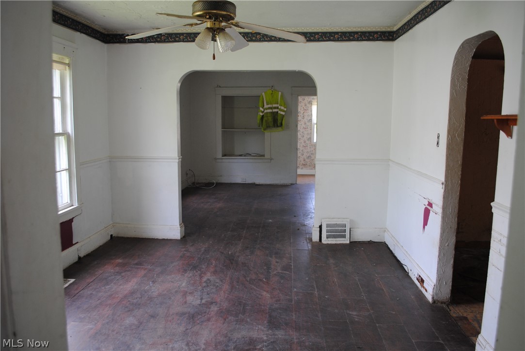 16110 Rockside Road Maple Heights, OH 44137 - Photo 13 of 17 Room featuring wood-finish flooring, wainscoting, and a ceiling fan
