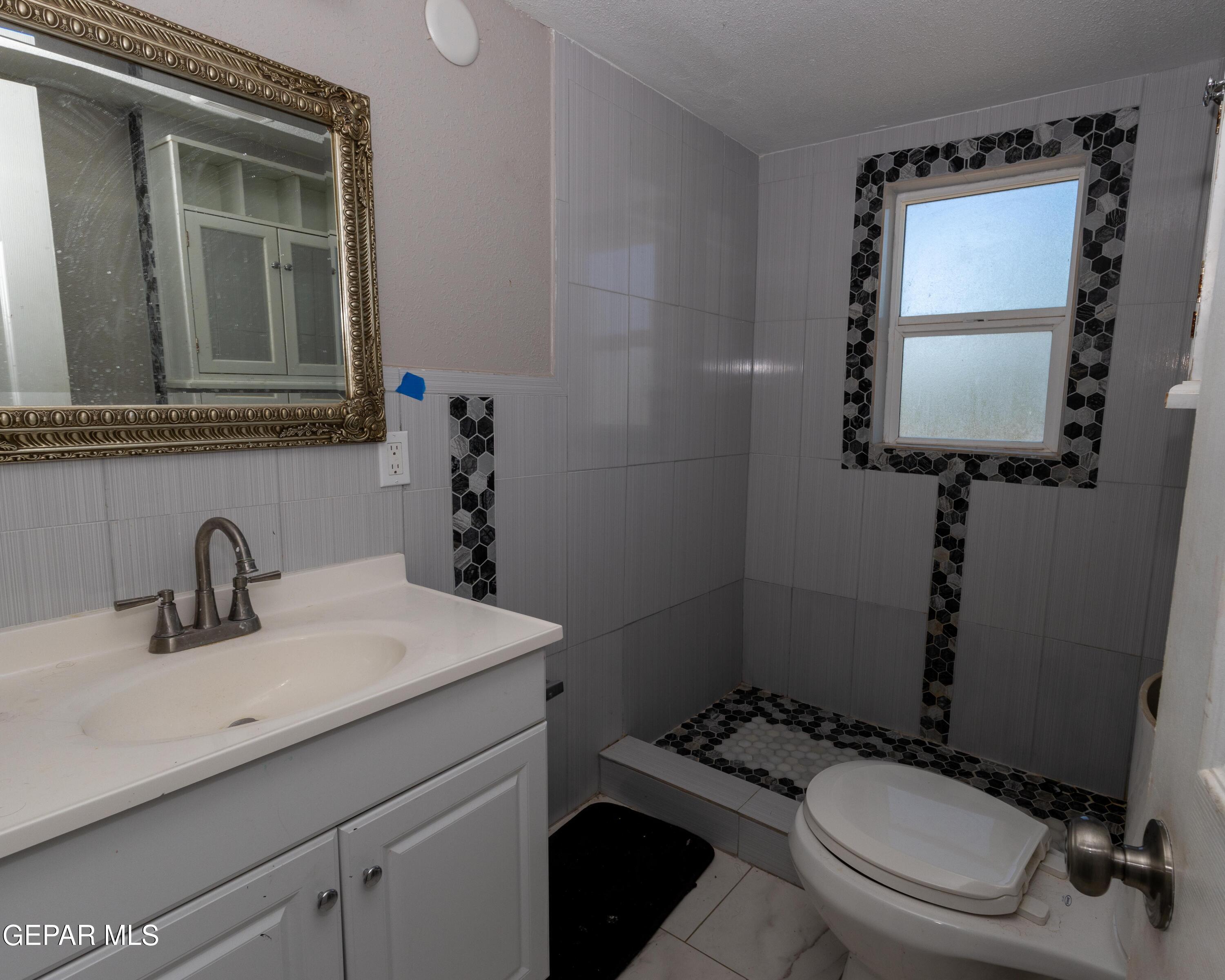 7860 Porche Street El Paso, TX 79915 - Photo 6 of 10 a bathroom with a toilet sink and mirror