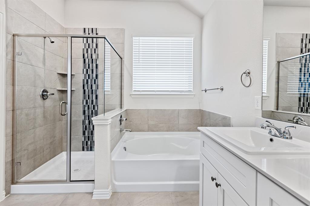 4149 Beale Street Heartland, TX 75114 - Photo 14 of 27 a bathroom with a tub shower and sink