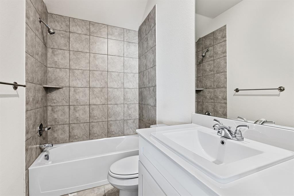 4149 Beale Street Heartland, TX 75114 - Photo 19 of 27 a bathroom with a bathtub shower sink vanity and toilet