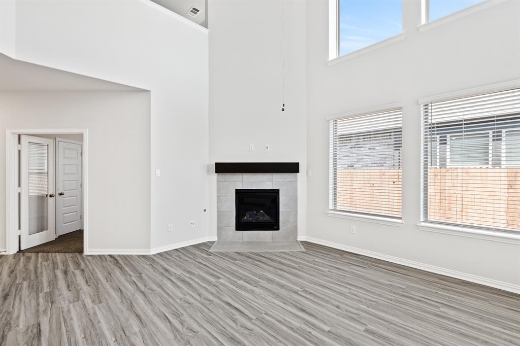 4149 Beale Street Heartland, TX 75114 - Photo 6 of 27 an empty room with windows and a fireplace